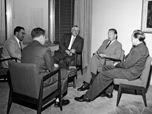 The Secretary-General of the UN and his Aides. An informal conference between Secretary-General Dag Hammarskjöld and some high officials of his Executive Office. From left to right are: Mr. Leo Malania, Senior Officer, Office of the Executive Assistant; Mr. Victor Mills, Executive Officer, Office of the Executive Assistant; Mr. Andrew W. Cordier, Executive Assistant to the Secretary-General; Mr. Dag Hammarskjöld; and Mr. Brian E. Urquhart, Secretary of the forthcoming International Conference on the Peaceful Uses of Atomic Energy (12 April 1955).