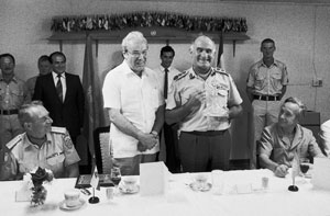 Secretary-General Pays Official Visit to the Middle East. At the special luncheon for the Secretary-General Javier Perez de Cuellar (standing centre, left), UNIFIL Commander Lt-General William Callaghan presents him with a glass decanter. Looking on (seated,right) are Brian E. Urquhart, Under-Secretary-General for Special Political Affairs and (seated left) UNIFIL Deputy Force Commander Brigadier-General G. Lund (10 June 1984). 