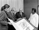 25 March 1983, Office of the Secretary-General, United Nations Headquarters, New York: Mr. Antonio Saura, President of the Paris-based Committee of Artists Against Apartheid (second from right) and Ambassador Alhaji Yusuf Maitama-Sule (Nigeria) (right), presenting anti-apartheid posters to Secretary-General Javier Perez de Cuellar (second from left), accompanied by Ms. Chantal Bonnet (left), interpreter. 