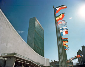 A view of the Headquarters of the United Nations in New York as seen from the north of the UN site. The buildings are the General Assembly (left) and the 39-storey Secretariat. The flags of 148 UN Member States fly in a row over 500 feet long overlooking the United Nations Plaza
