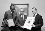 15 September 1971 - United Nations Headquarters, New York. Mr. Maurice F. Strong, Secretary-General of the United Nations Conference on the Human Environment (right), shows United Nations Secretary-General U Thant a design for the official Conference poster. To the left is Mr. Keith Johnson (Jamaica), Chairman of the Preparatory Committee for the Conference. (Photo Credit: UN Photo/Teddy Chen)