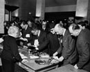 17 March 1960 Opening meeting of the Second United Nations Conference on the Law of the Sea, Geneva, Switzerland: after the conclusion of the opening meeting, delegates gather around the photograph counter to select shots of the Opening Ceremony. 